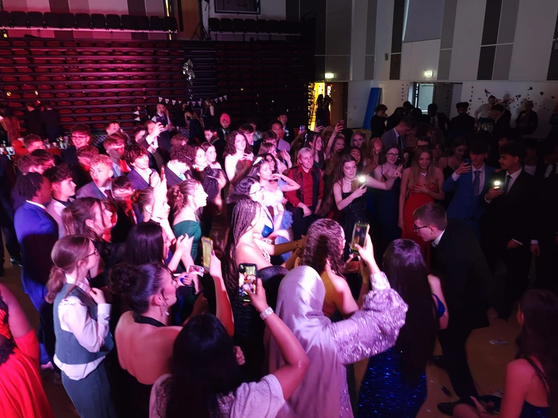 students dancing and taking photos at a prom
