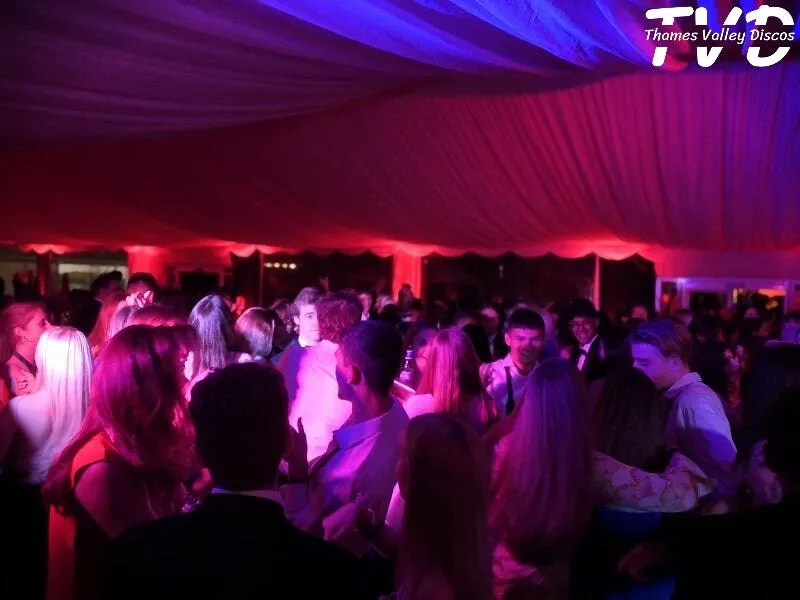 people dancing in a marquee with uplighting in red