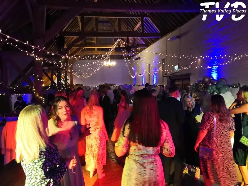 people dancing at a wedding in a barn