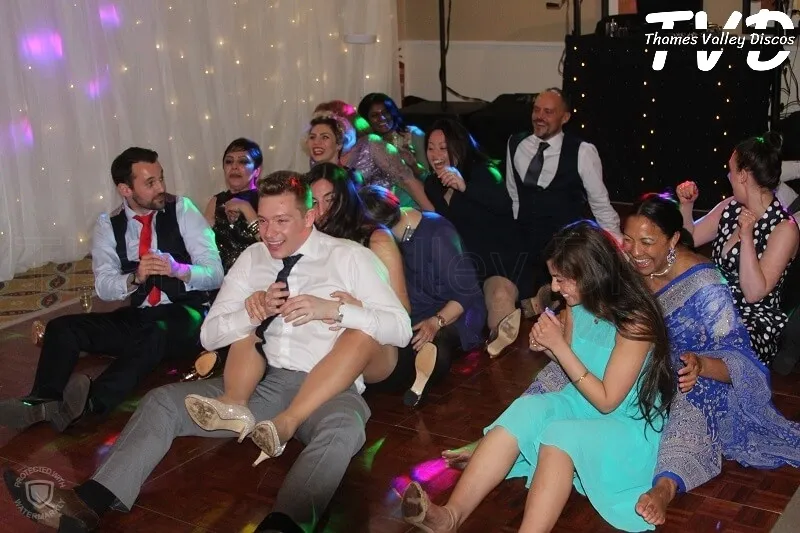 people sat on the floor doing the rowing boat song